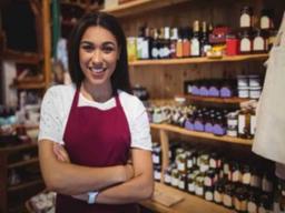 imagem de uma mulher com um avental vermelho em uma loja para ilustrar o conteúdo sobre negócios que dão lucro em cidades pequenas