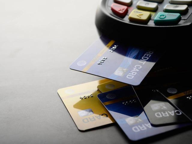 Cartões de crédito e maquininha de cartão representando as mudanças no novo teto de juros do rotativo