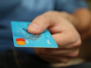 Imagem de uma pessoa usando cartão de crédito, simbolizando nosso conteúdo sobre melhor dia para compra no cartão