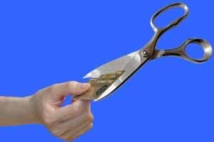 Cartão de crédito sendo cortado com uma tesoura simbolizando o tema Como sair das dívidas do cartão de crédito