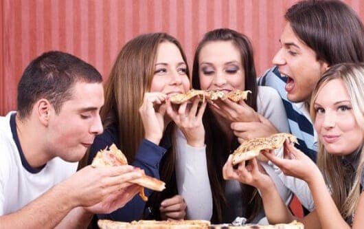 Vários amigos dividindo uma pizza