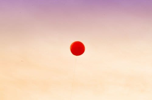 Foto de um balão vermelho voando no céu