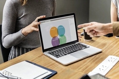 Mulher apresentando uma análise SWOT no notebook