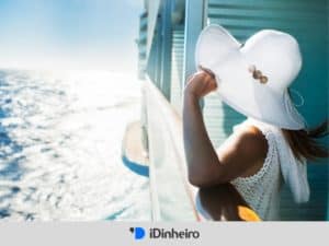 mulher de chapéu admirando o mar em uma viagem de cruzeiro