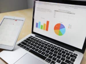 Sistema de controle financeiro empresarial: computador com gráficos e um tablet com calendário