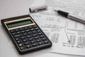 calculadora, papel e caneta simbolizando o tema: adequar o orçamento
