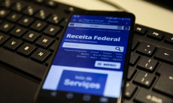Celular acessando o site da Receita Federal na aba dos lotes de restituição do imposto de renda