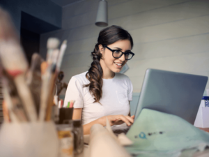 Imagem de uma mulher usando o computador para aprender como viver de renda