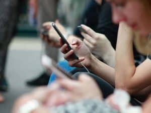 Imagem de uma série de pessoas usando o celular como forma de representar a notícia 