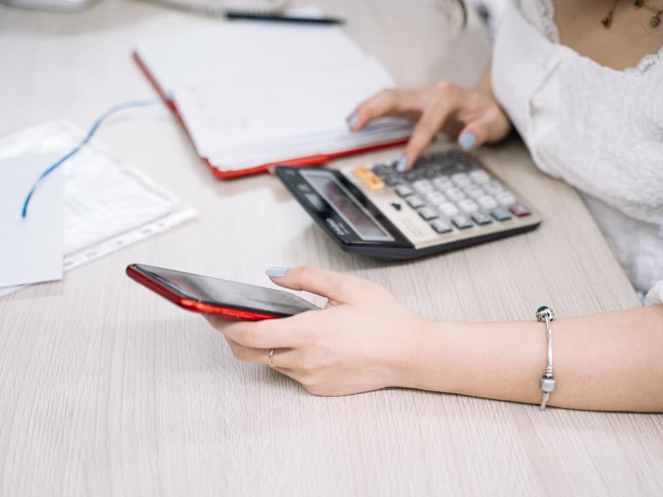 Imagem de uma pessoa usando a calculadora para entender seu salário líquido