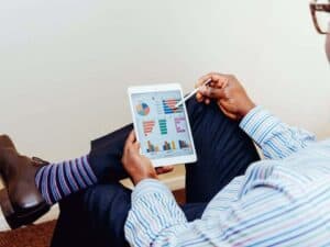 Imagem de um homem usando um tablet para aprender como investir em fundos imobiliários