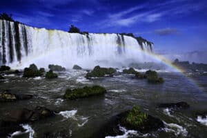 Quedas das Cataratas do Iguaçu, em Foz do Iguaçu, com o rio na frente e um arco-íris