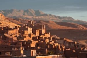 cidade de marrocos com paisagem ao fundo. Tudo em cor de barro e sem destaques