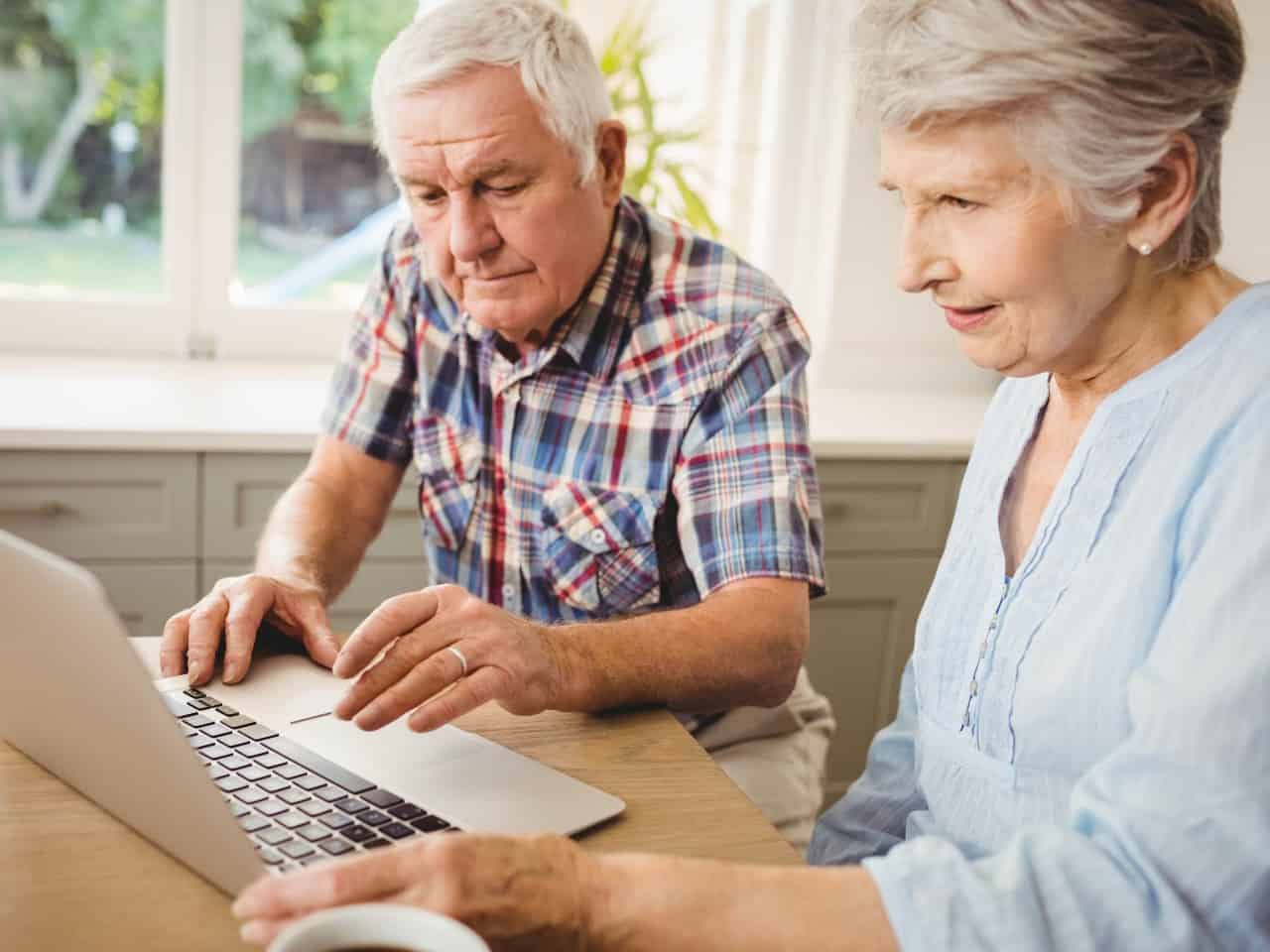 Imagem de dois idosos usando o computador para representar nosso post sobre a tabela IPCA
