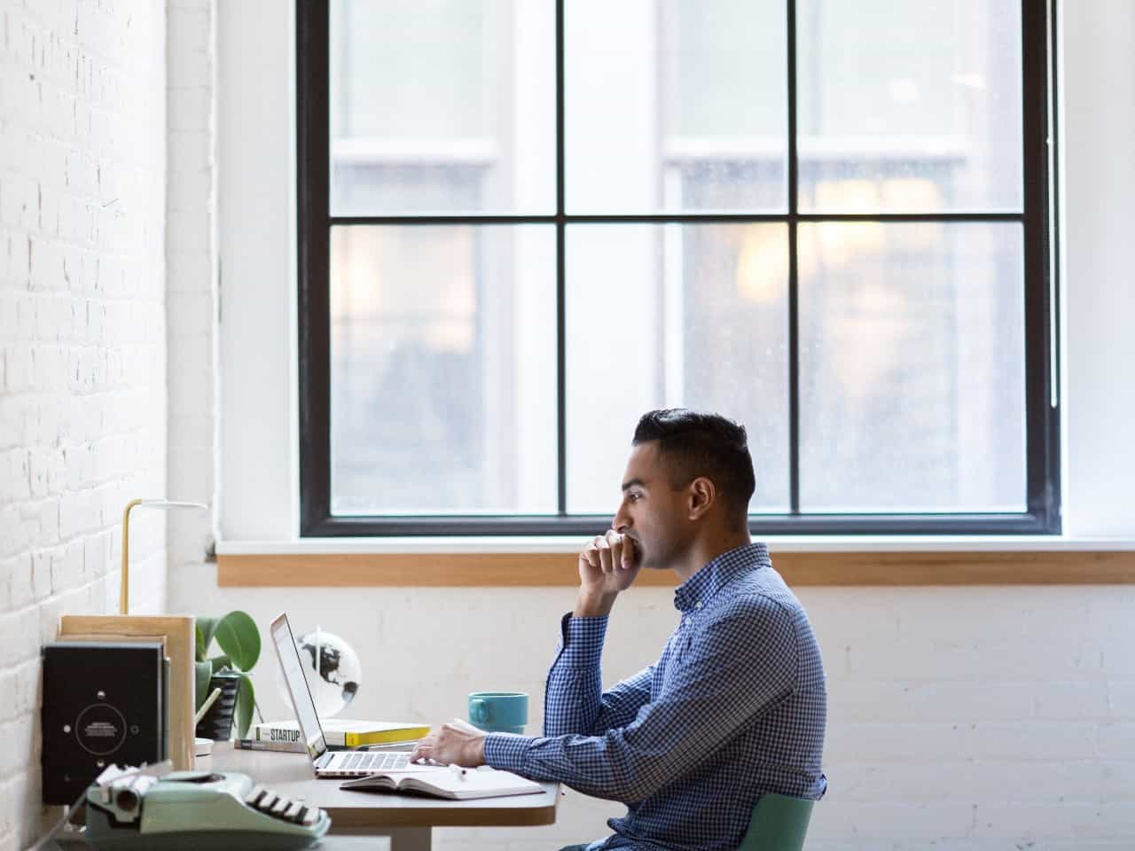 Imagem de um homem trabalhando com o computador em um escritório, simbolizando nosso post sobre a tabela IPCA-E 2021