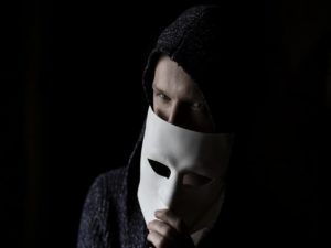 hacker tirando a máscara representando golpes envolvendo revisões de benefícios