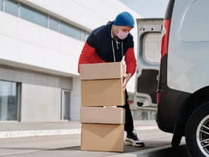 Imagem de um homem colocando encomendas em um carro, representando o negócio de redirecionamento de encomendas