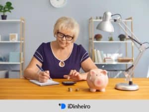 mulher idosa sentada à mesa fazendo cálculos, representando carteira previdenciária