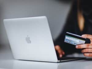 imagem de uma pessoa usando o notebook com um cartão de crédito na mão para simbolizar os melhores gateways de pagamento