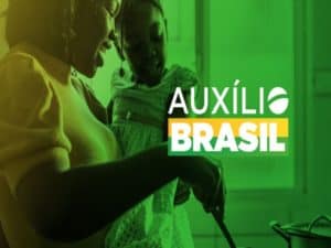 mulher com criança no colo e cozinhando representando pagamento do Auxílio Brasil
