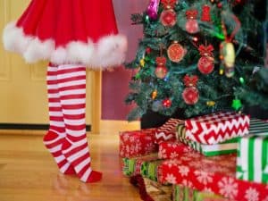 pernas de Mamãe Noel e presentes em árvore de Natal representando como terminar o ano no azul