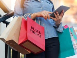 Mulher com sacolas de compra representando comprar com segurança na black friday.