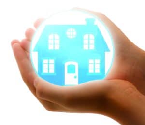 uma mão segurando uma casa dentro de uma bolha