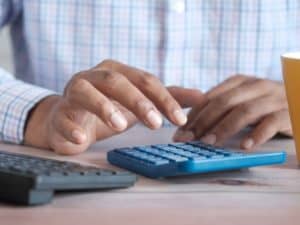 imagem de um homem usando uma calculadora para ilustrar o artigo sobre o que é capital de giro
