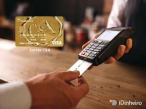 Imagem de uma pessoa inserindo um cartão de crédito em uma maquininha de cartão. Ao lado uma imagem do cartão da CeA e a logo do idinheiro no canto inferior direito