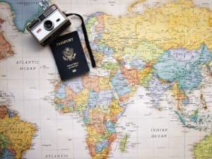 passaporte e camera em cima de um mapa mundi