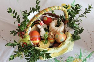 Cesta de Páscoa com ovos coloridos e ramos de flores