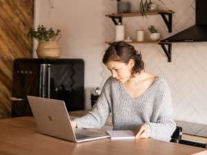 imagem de uma mulher usando um computador para ilustrar o artigo sobre banco Cora é confiável