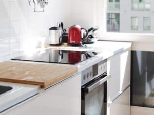 Imagem de um fogão em uma cozinha da cor branca, representando nosso conteúdo sobre consórcio de eletrodomésticos