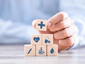 Imagem com alguns símbolos ligados à área da saúde, como medicamento, agulha e coração. Imagem utilizada para ilustrar uma notícia sobre o reajuste dos planos de saúde 2022.