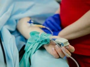 Imagem de uma pessoa em uma cama de hospital com aparelho de oxigenação no dedo. Foto usada para ilustrar o post sobre auxílio-doença do INSS