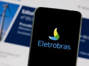Imagem de um celular com a logo da Eletrobras. Imagem utilizada para ilustrar uma notícia sobre as ações da Privatização da Eletrobras. Crédito: Gabriel_Ramos/Shutterstock.