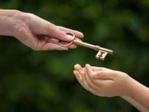 adulto entregando uma chave para uma criança, simbolizando a herança