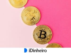 moedas douradas com símbolo do bitcoin fundido em cima de cores sólidas rosa de tom claro e de tom escuro, divididas cada uma em 50% do fundo