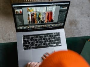 Como montar uma loja virtual de roupas: pessoa configurando seu e-commerce de roupas em um laptop