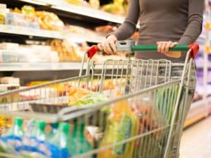 Imagem de uma pessoa fazendo compras com um carrinho em um supermercado. Imagem utilizada para ilustrar uma notícia sobre a inflação ipca agosto 2022.