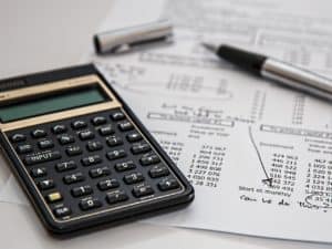 planilha de controle financeiro empresarial: calculadora e caneta sobre papéis de contabilidade