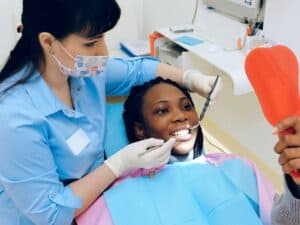 dentista cuidando da paciente no consultório de uma franquia odontológica
