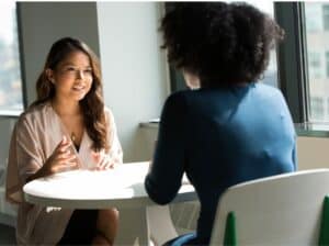 imagem de duas mulheres conversando em uma mesa para o texto sobre Banco Safra Empréstimo para MEI