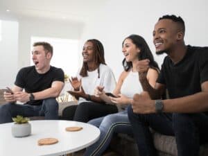 Imagem de quatro pessoas assistindo a TV utilizada para ilustrar uma notícia sobre jogo do Brasil na Copa é folga. Créditos: Pexels.