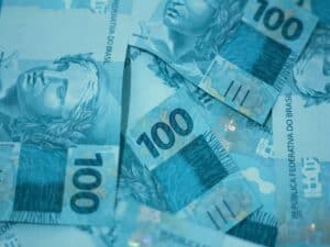 notas de 100 reais representando negociar dívidas Santander