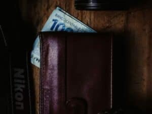 Imagem de um carteira marrom com uma cédula de 100 reais. Foto utilizada para ilustrar uma notícia sobre o prazo de pagamento do décimo terceiro. Crédito: Unsplash.
