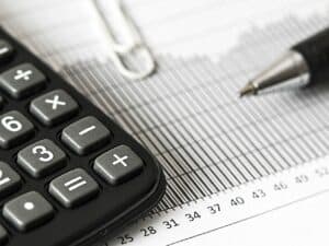 Imagem de uma calculadora ao lado de uma caneta. Foto utilizada para ilustrar uma notícia sobre a declaração do Imposto de Renda 2023.