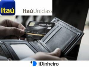 mão recolhendo um cartão de crédito de uma carteira. Acima, símbolo oficial do Itaú Uniclass