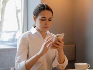 imagem de uma mulher usando um celular para o artigo sobre a conta Ton