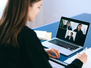 mulher participando de uma reunião online em uma empresa digital pelo seu laptop
